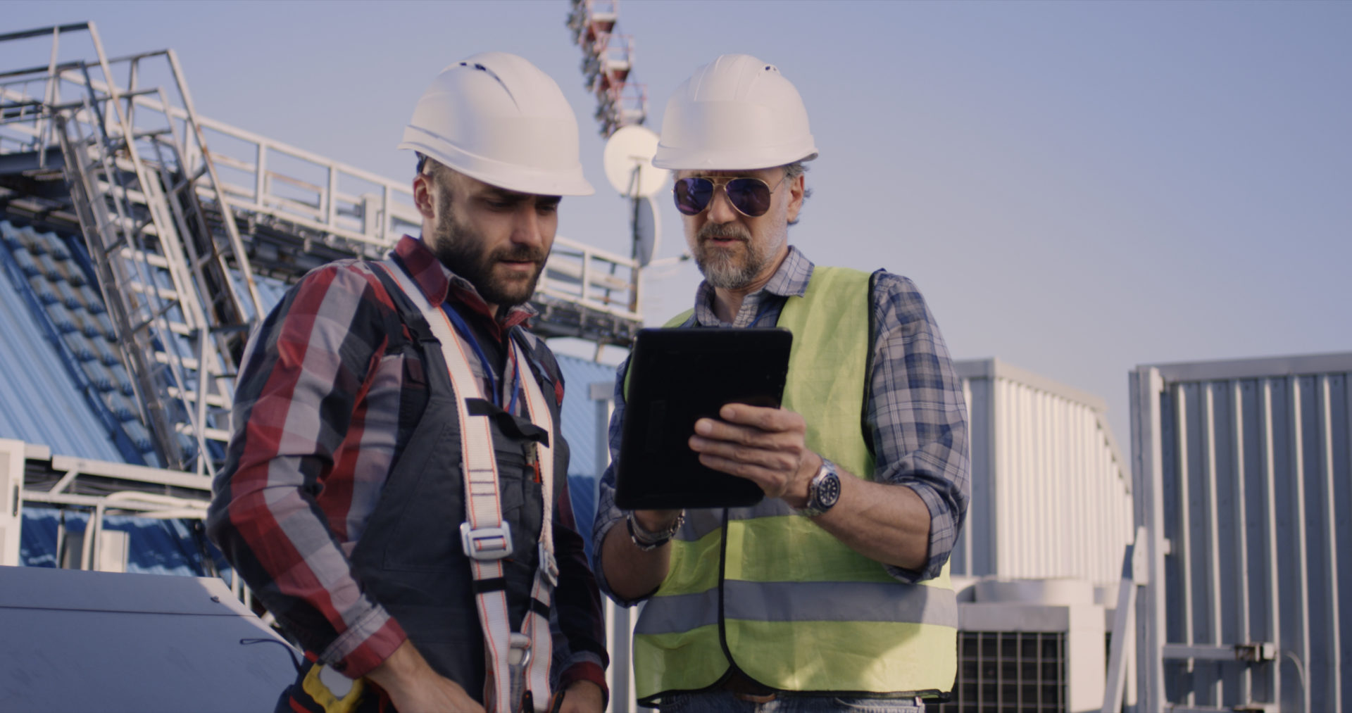 Medium close-up of engineers using a tablet while having a discussion